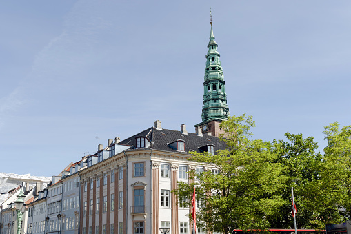 Downtown Copenhagen with old houses and church on a sunny day.