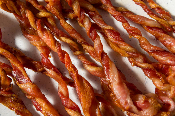 Homemade Trendy Twisted Bacon Strips Homemade Trendy Twisted Bacon Strips on a Plate twisted bacon stock pictures, royalty-free photos & images