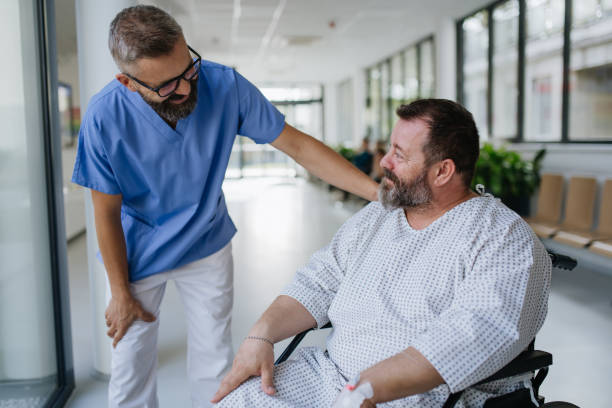 Close up of supportive doctor talking with worried overweight patient in wheelchair. Illnesses and diseases in middle-aged men's health. Compassionate physician supporting stressed patient. Concept of health risks of overwight and obesity. stock photo