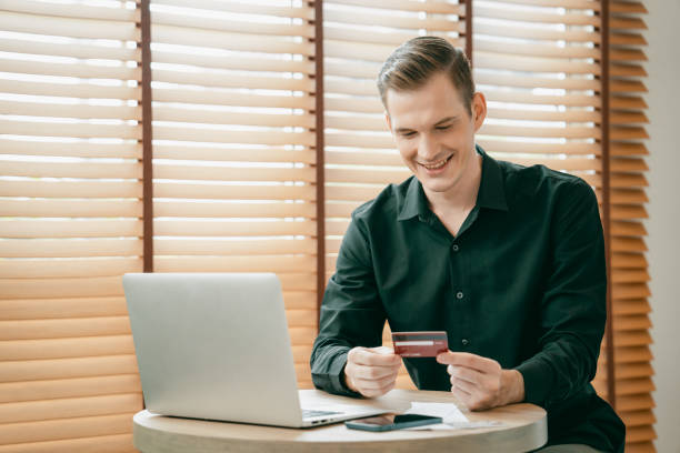 istock Young man using laptop with credit card for internet banking. Unveiling 1796944648