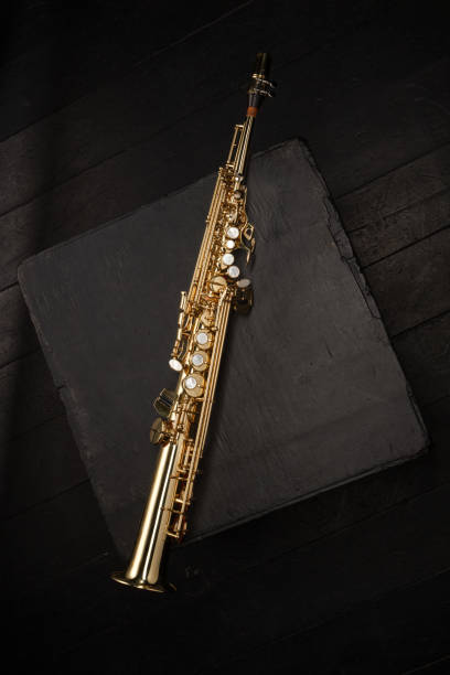 istock Straight golden saxophone on a black cube and a black background 1796952362