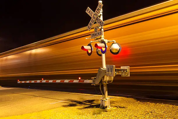Photo of train passes a crailway crossing by night at route 66
