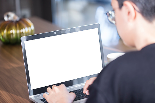 Teenager boy using laptop with an blank white screen