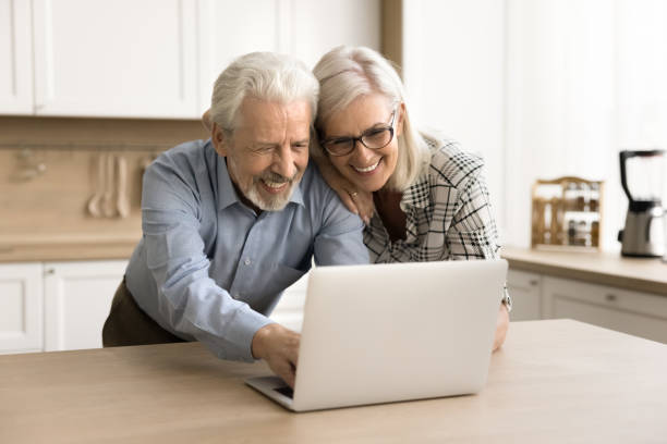 istock Happy elder husband and wife using online application on laptop 1796991874