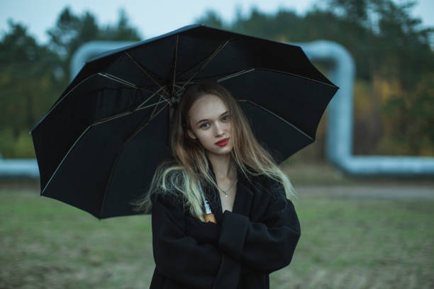 Woman with umbrella on the field.