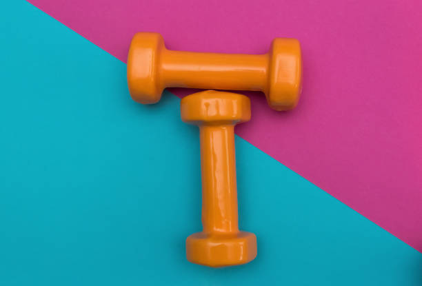 istock Two dumbbells for sport on the pink blue background. 1797011587