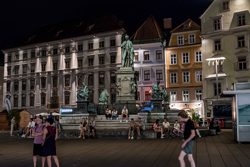 Graz, Austria - August 26, 2023: Night view of the main square, with the Archduke John Brunner fountain