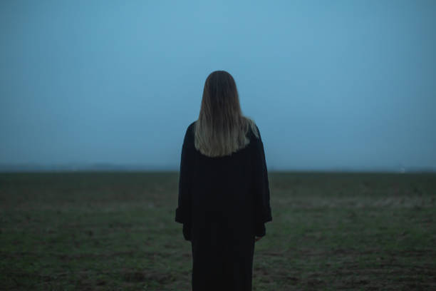フィールド上のブロンドの女性。空の背景。 - teenager dark pensive emotional stress ストックフォトと画像