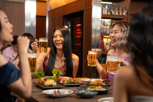 Group of asian people having mini party together in bar. They enjoying with night party together. Party, Lifestyle, Happiness, Cheerful and Celebration concept.
