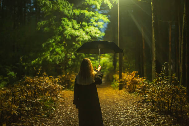 istock Woman with umbrella at night. 1797034400