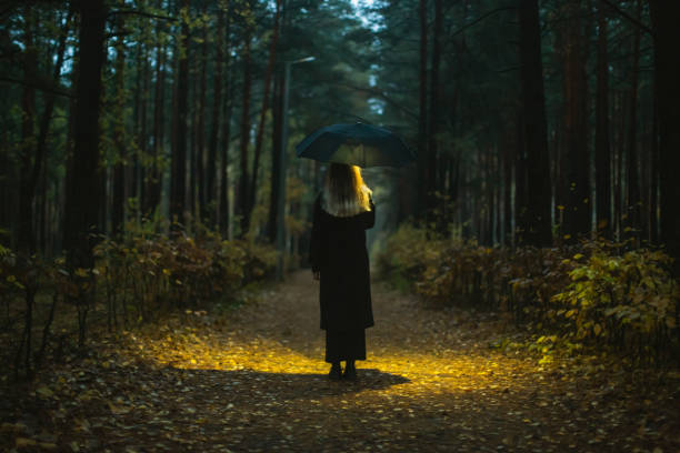 istock Woman with umbrella at night. 1797038642