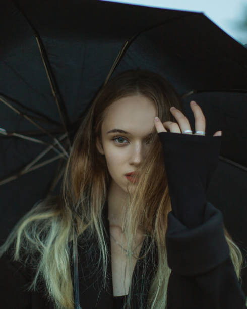 Woman with umbrella on the field.