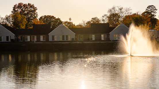 Care and cleaning services in one-story houses line the sunny fountain on sunny autumn evening in Newport News, VA