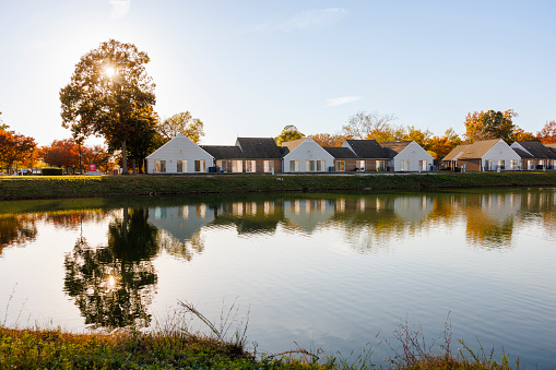 Residential and commercial houses line the sunny lake in autumn day in Newport News, VA