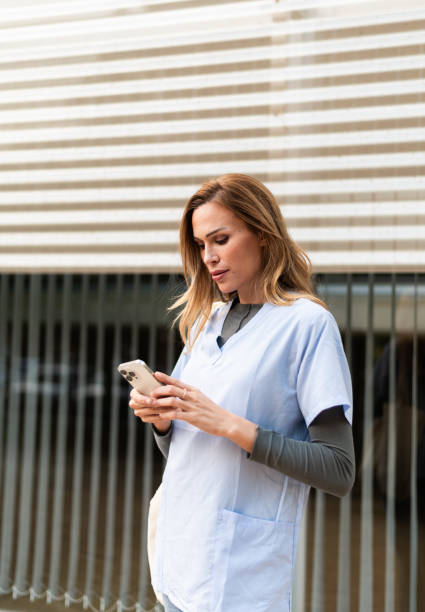 istock Nurse taking a break using phone outside the hospital 1797088520