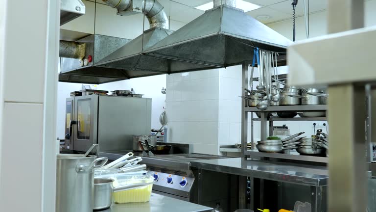 Restaurant kitchen without people, kitchen utensils, pots, trays and pans.