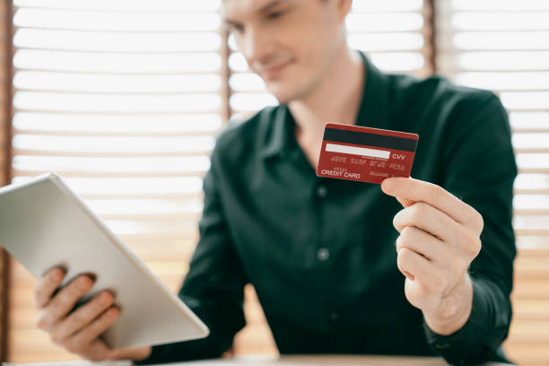 istock Young man using tablet with credit card for internet banking. Unveiling 1797111079