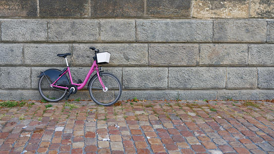Pink bicycle parked on a wall on the banks of the Vltava River in Prague, Czech Republic