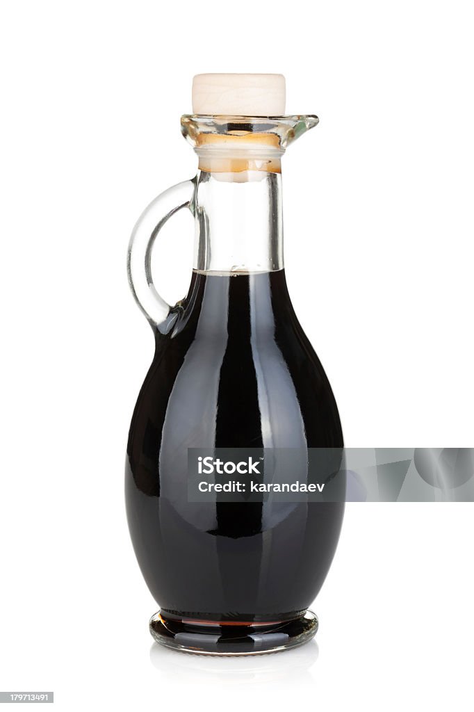 Glass bottle with handle full of black liquid Vinegar bottle. Isolated on white background Balsamic Vinegar Stock Photo