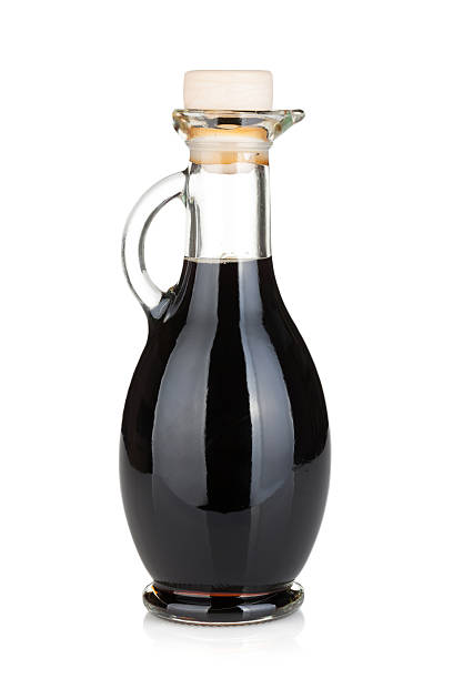 Glass bottle with handle full of black liquid Vinegar bottle. Isolated on white background vinegar bottle stock pictures, royalty-free photos & images
