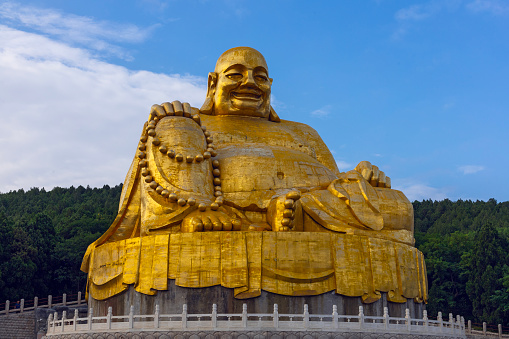 JINAN, CHINA, JUNE 26, 2023: Big golden statue of Maitreya Buddha in Qianfo Shan, also called mountain of the one thousand buddha, Jinan, Shandong Province, China