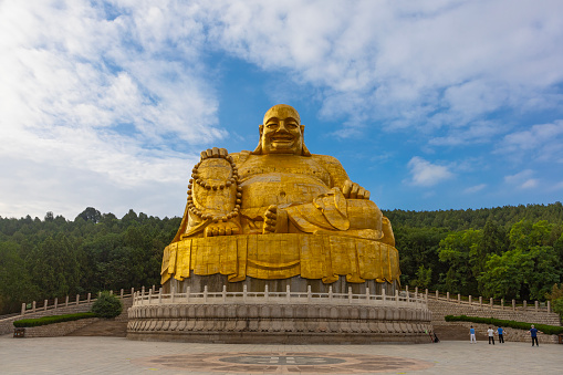 JINAN, CHINA, JUNE 26, 2023: Big golden statue of Maitreya Buddha in Qianfo Shan, also called mountain of the one thousand buddha, Jinan, Shandong Province, China