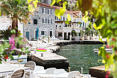 View of beautiful Rose village quayside on Lustica peninsula, Kotor Bay, Montenegro. Beautiful blurred flowers and grapevine frame