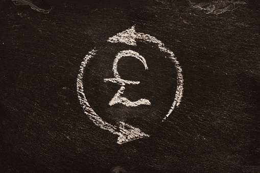 Иконка , символ обмена валют , фунта со стрелками, рисунок мелом на доске. Крупным планом.