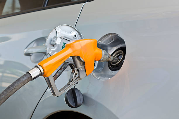 grey car at gas station being filled with fuel stock photo