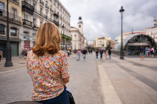 Tourist woman with her back turned in the Puerta del Sol square in Madrid, Spain