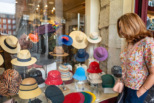 Tourist woman looking at the hats of an old shop in the center of Madrid, Spain