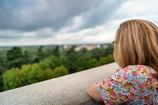 Tourist woman enjoying the views of Madrid's Casa de Campo from a terrace, Spain.