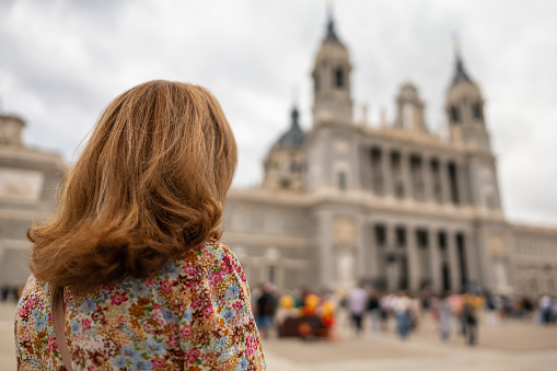 Tourist woman looking at the imposing facade of the Almudena Cathedral in Madrid