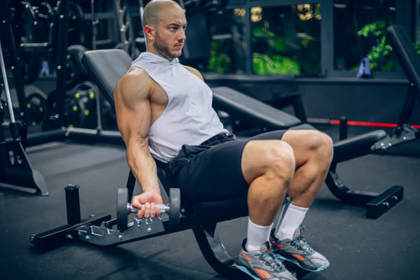 istock Young man training in gym with dumbbells 1797215757