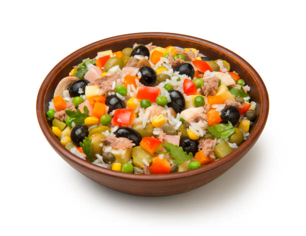 Italian rice salad with tuna in a brown ceramic salad bowl isolated on a white background. stock photo