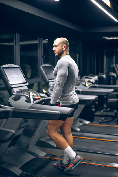 istock Young man using the treadmill in the gym 1797231525