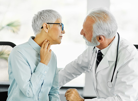Portrait of a senior elderly doctor and patient at doctor's office in clinic