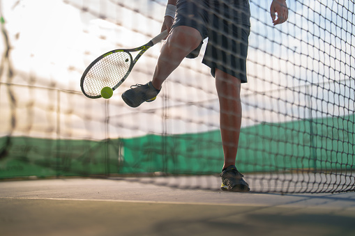 Tennis player is warming up at the tennis court