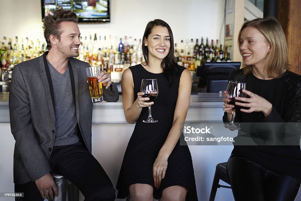 Tres amigos y socializar y bebidas en la barra mostrador Sonriendo - Foto de stock de Restaurante libre de derechos