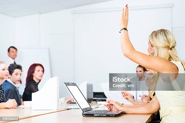 Mature Women Raising Hand To Ask Question During Seminar Stock Photo - Download Image Now