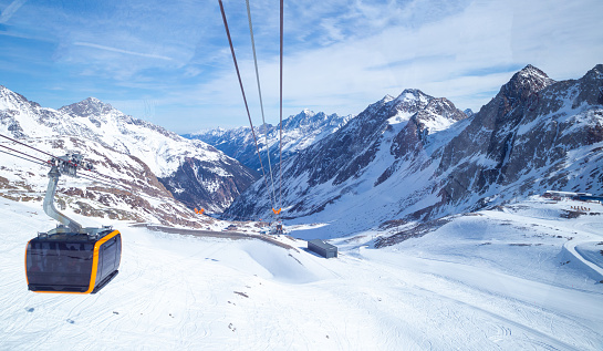 panoramic view of Alps mountain snowy range with skiing trails and cable car in Stubai Glacier, winter