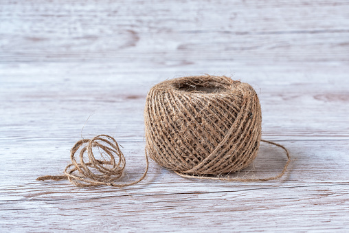A spool of jute thread. Jute twine. Sisal rope for packing and needlework. Natural textile fiber.