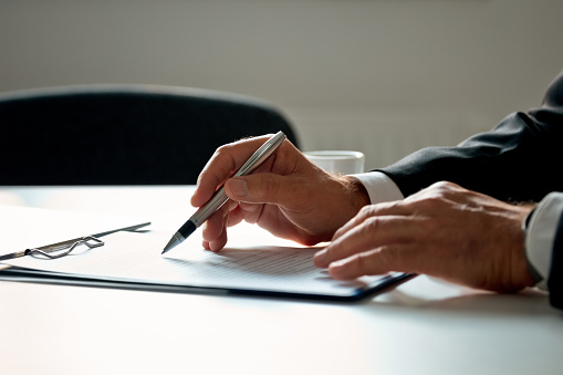 Businessman signing a contract. Close up of hands, unrecognizable person.