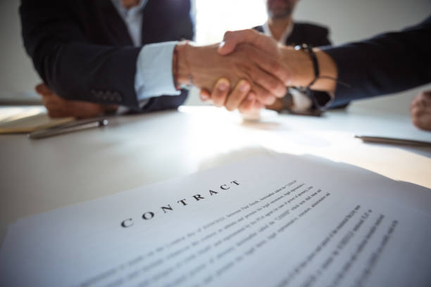 istock Businessmen shaking hands over contract 1797261561
