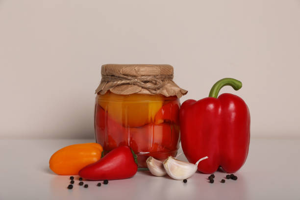 istock Tasty pickled peppers, fresh vegetables and garlic on white table 1797262673