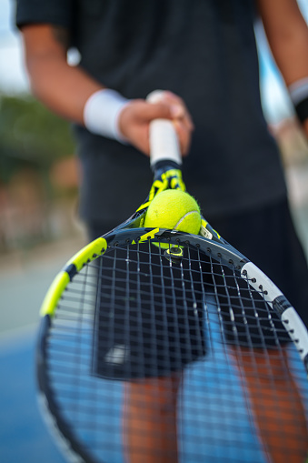 Achieve the impossible: Tennis ball is trapped in the neck of the racket.