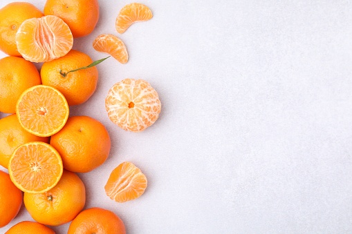 Fresh juicy tangerines on light grey table, flat lay. Space for text