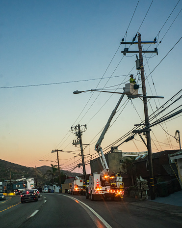 Power Utility Workers on a Crane doing repairs on a Utility Pole