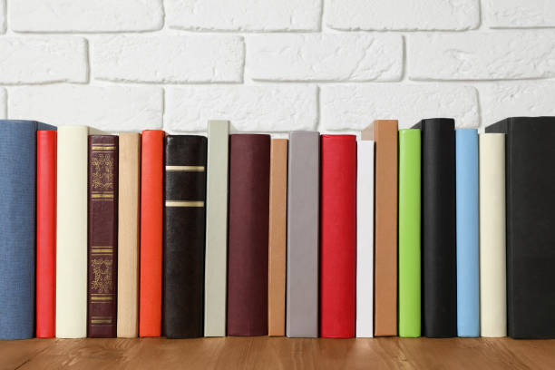 istock Books on wooden table near white brick wall 1797298199