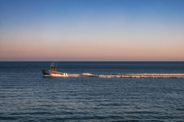 istock Lifeguard Boat going by through the California Sunset 1797300311